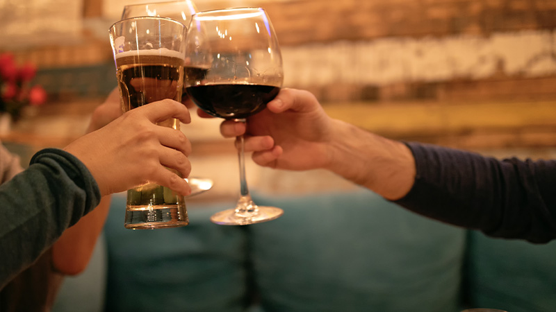 family gathered around a table playing a board game with drinks enjoying quality time together six players engaged in fun activities