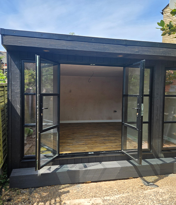 black garden office with open doors and wooden floor showcasing spacious interior design 2 modern 2 outdoor space