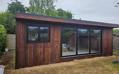 modern wooden garden shed with large windows showcasing natural surroundings and five outdoor design ideas